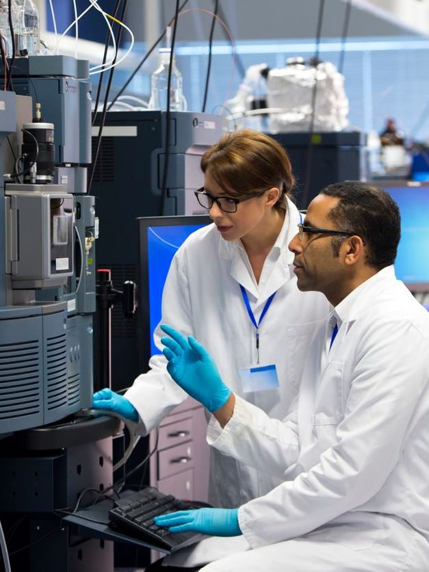 Male and a female scientist conducting research with a mass spectrometer.